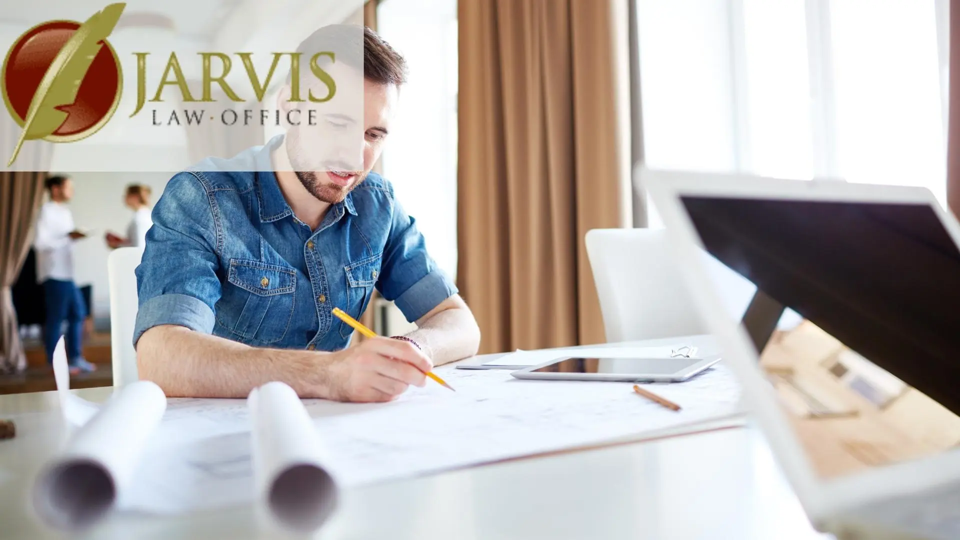 Man reviewing documents at desk with laptop