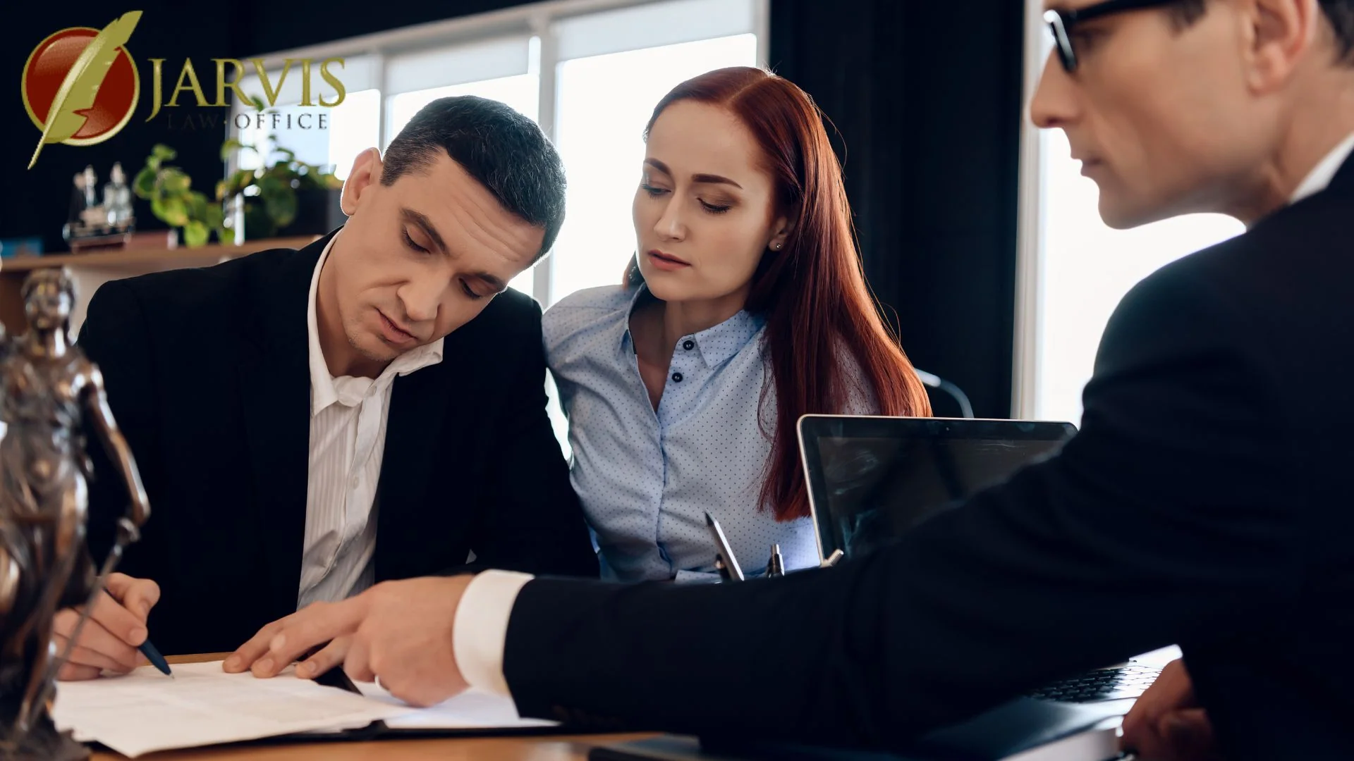 Couple reviewing documents with attorney in office