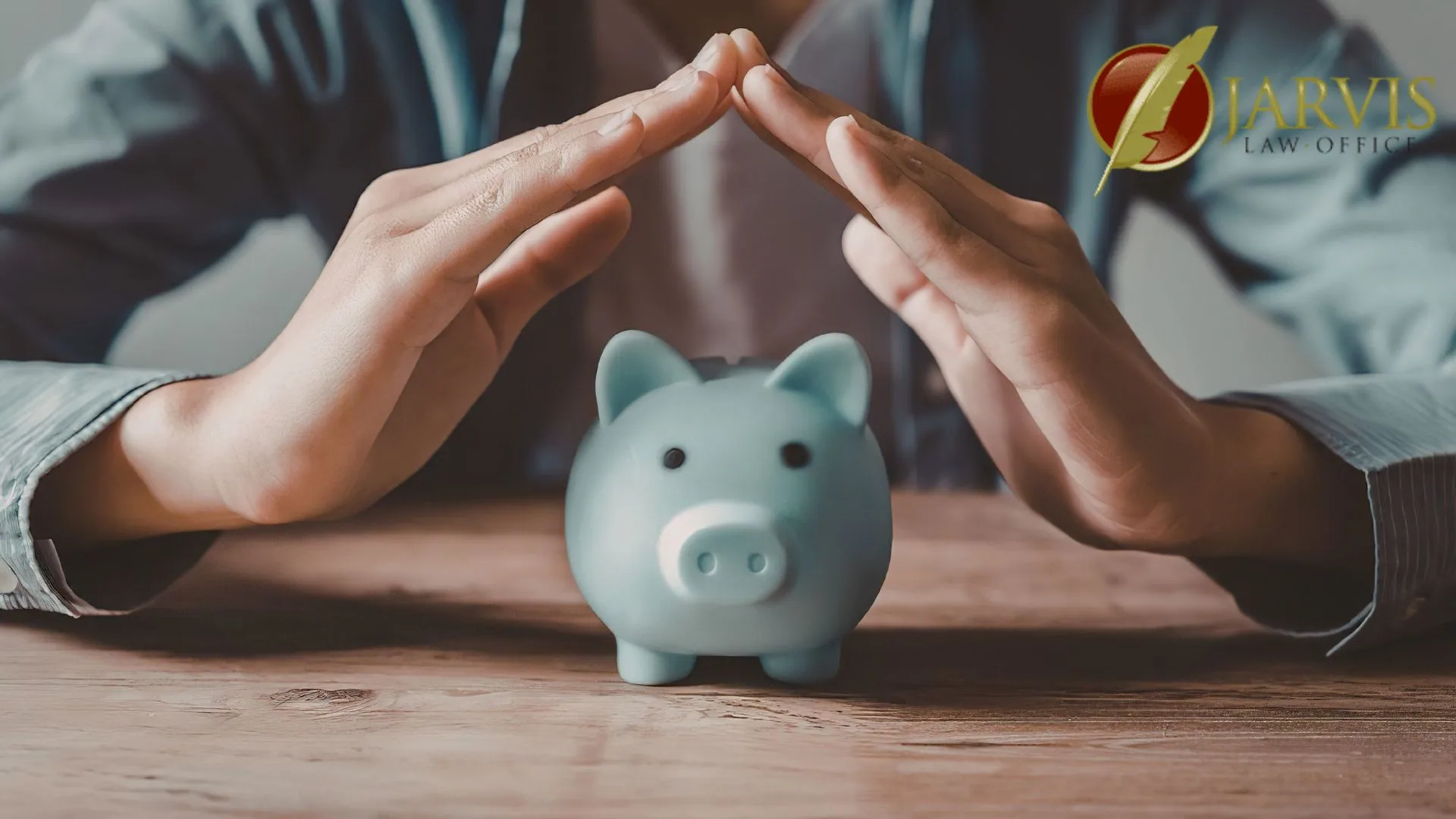 Hands shielding piggy bank on wooden table