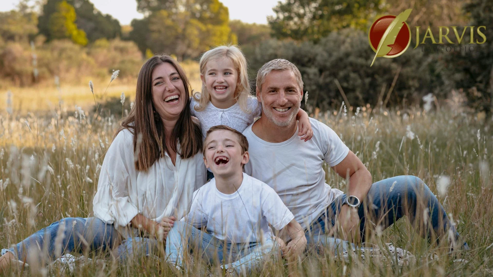Happy family sitting in grassy field outdoors