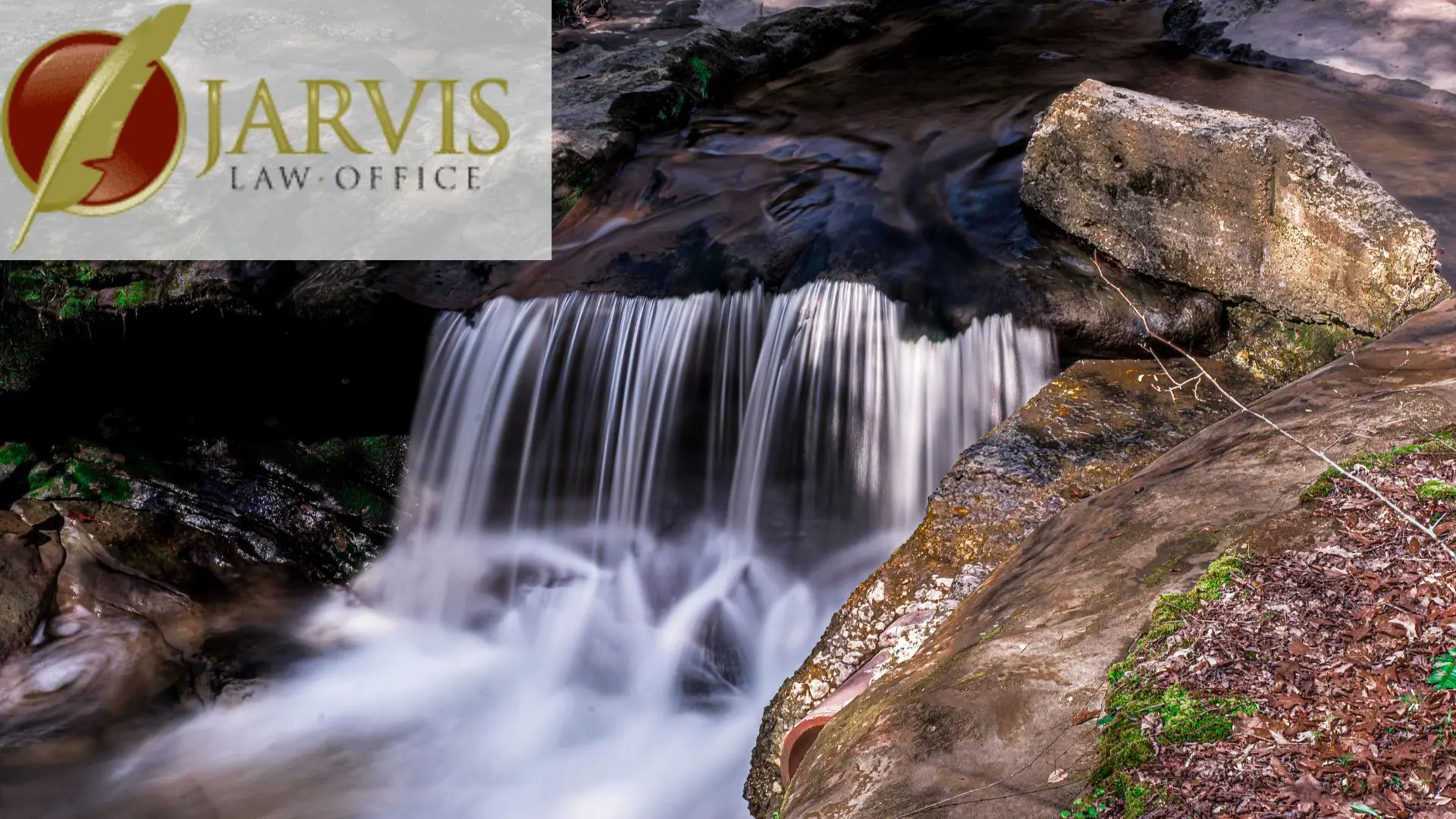 Small waterfall over rocks with law office logo