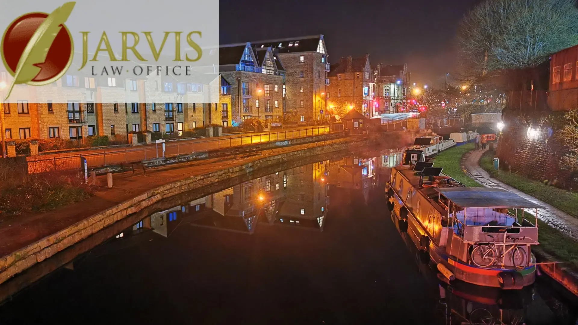 Nighttime canal with boats and city lights