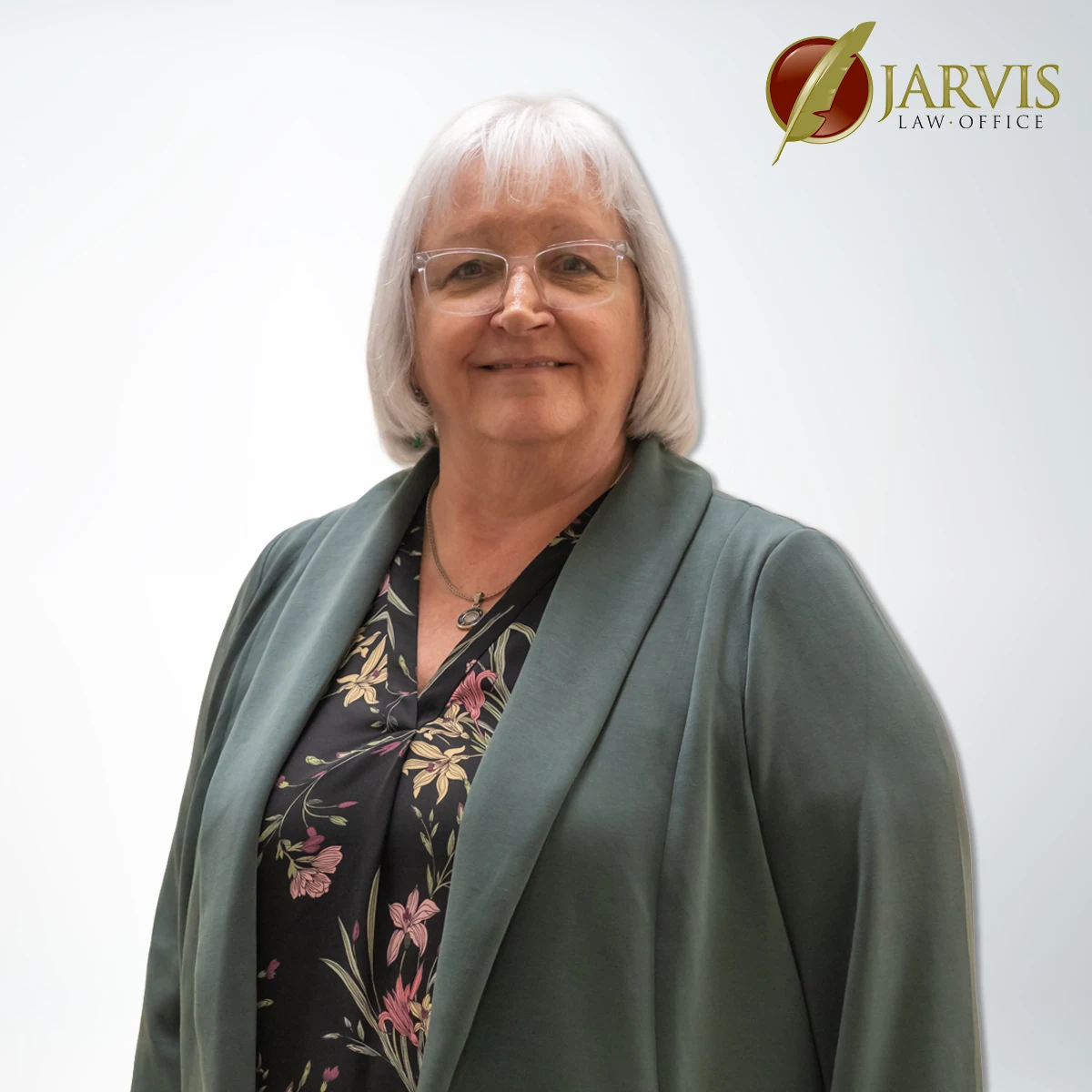 Smiling woman in floral blouse and green jacket