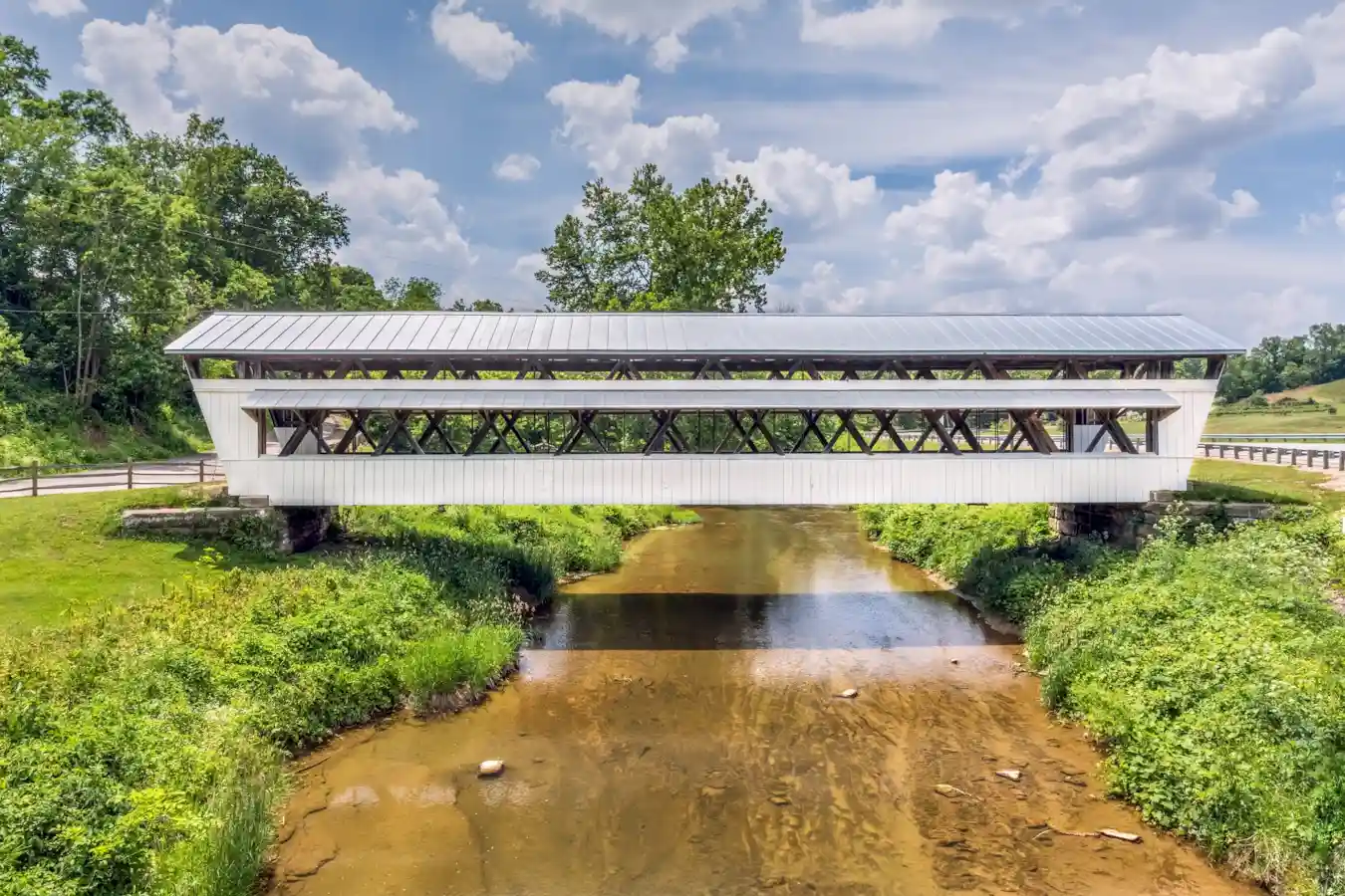 Covered bridge over a scenic river landscape.