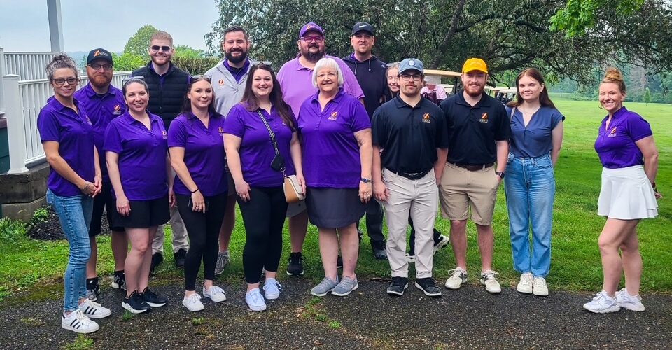 Group of people posing outdoors on golf course