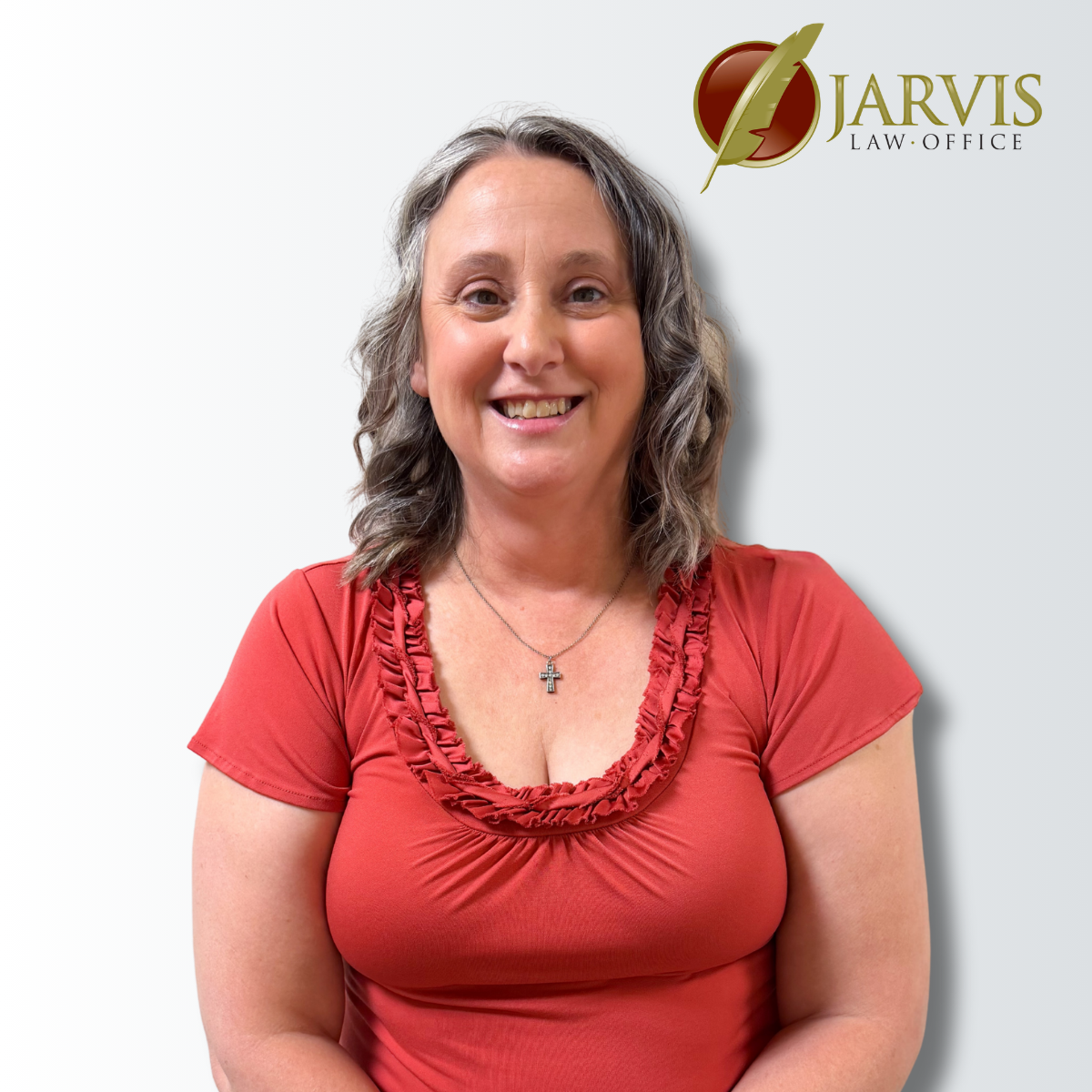 Smiling woman in red top, law office backdrop